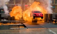 A car sppeds through a firey blaze at Lights. Cameras, Action. Extreme Stunt SHow that is in Disney’s Hollywood Studios.